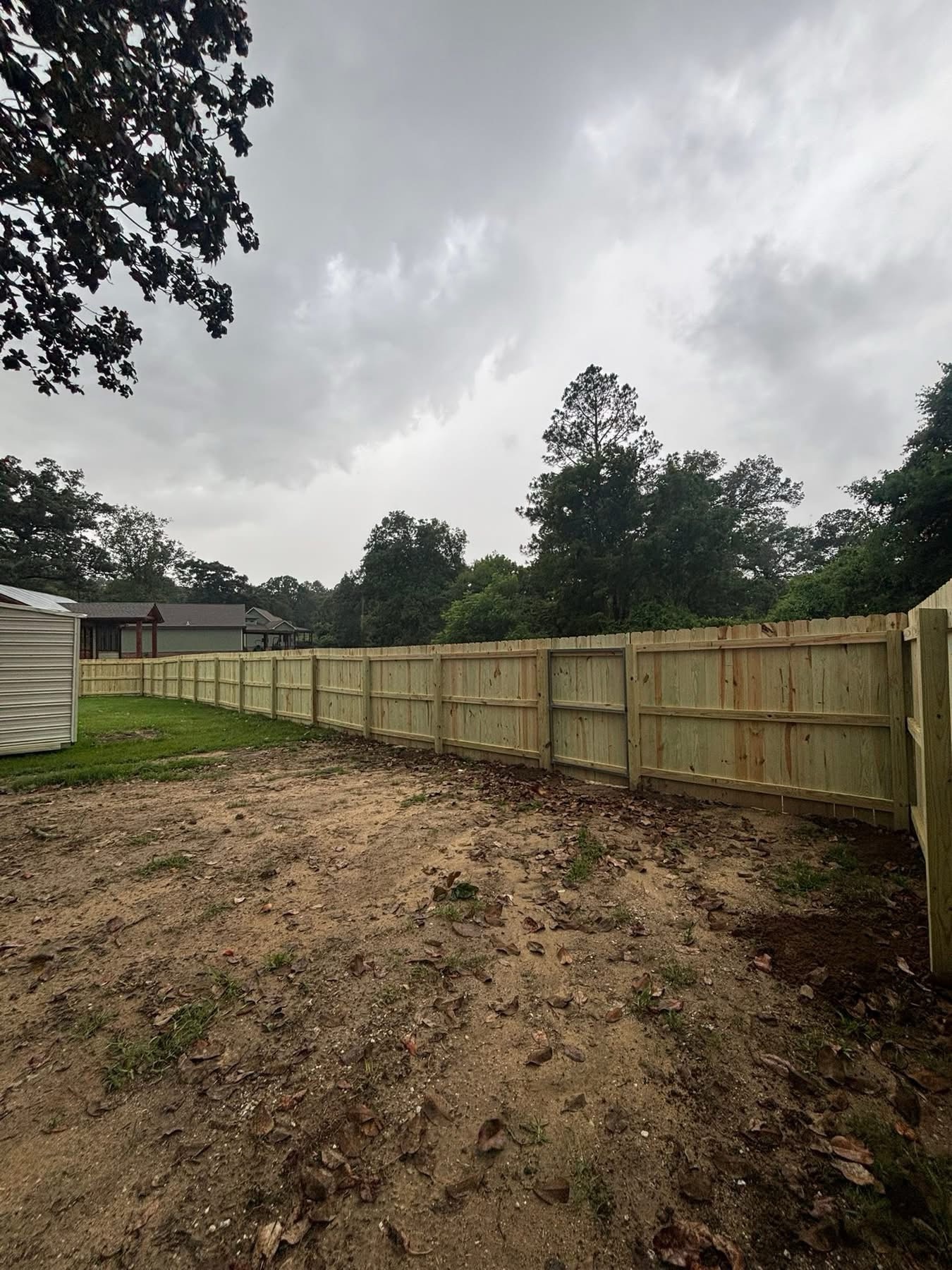 Long wood privacy fence run along property
